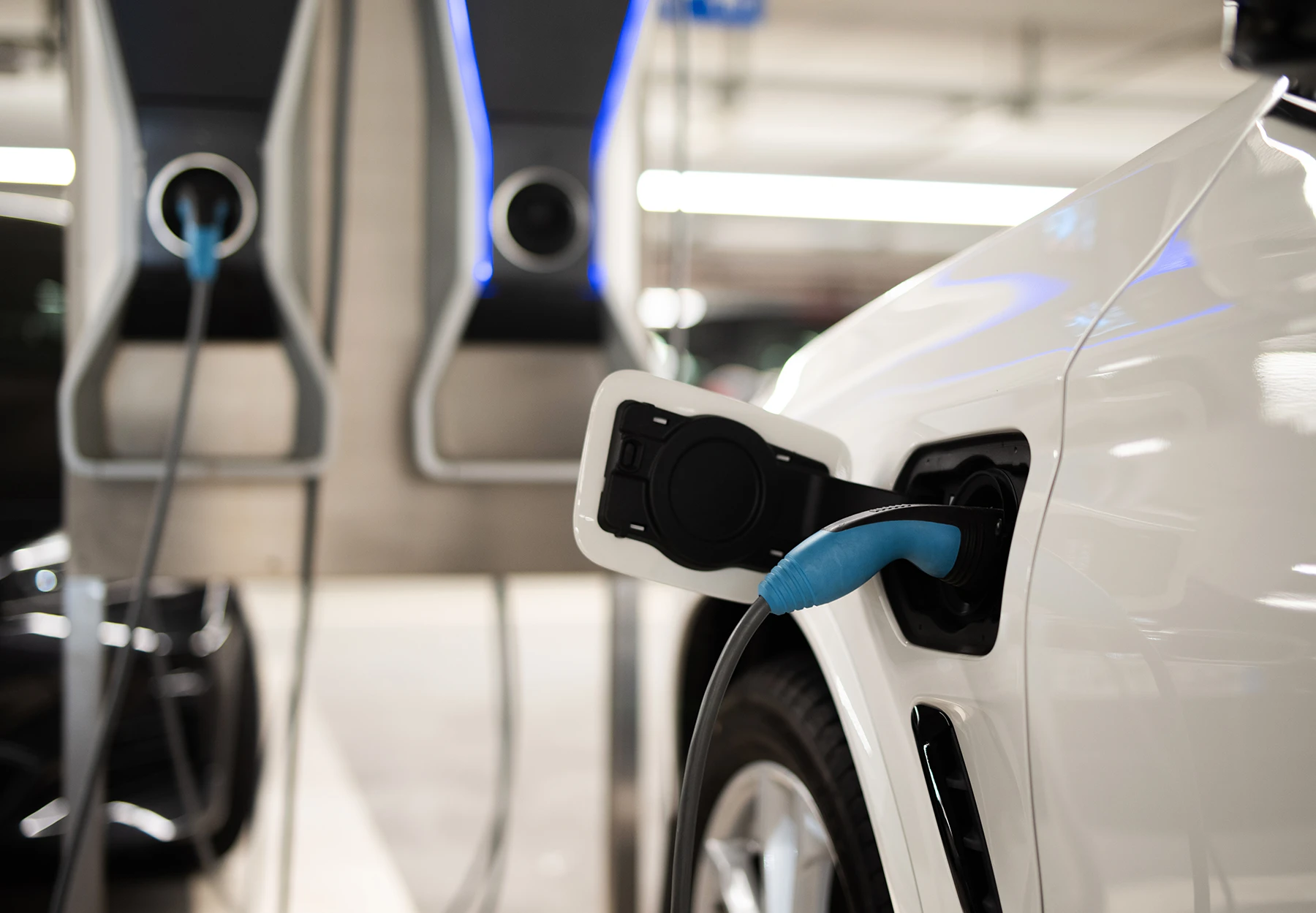 E-Ladestation an einem weißen Fahrzeug angeschlossen